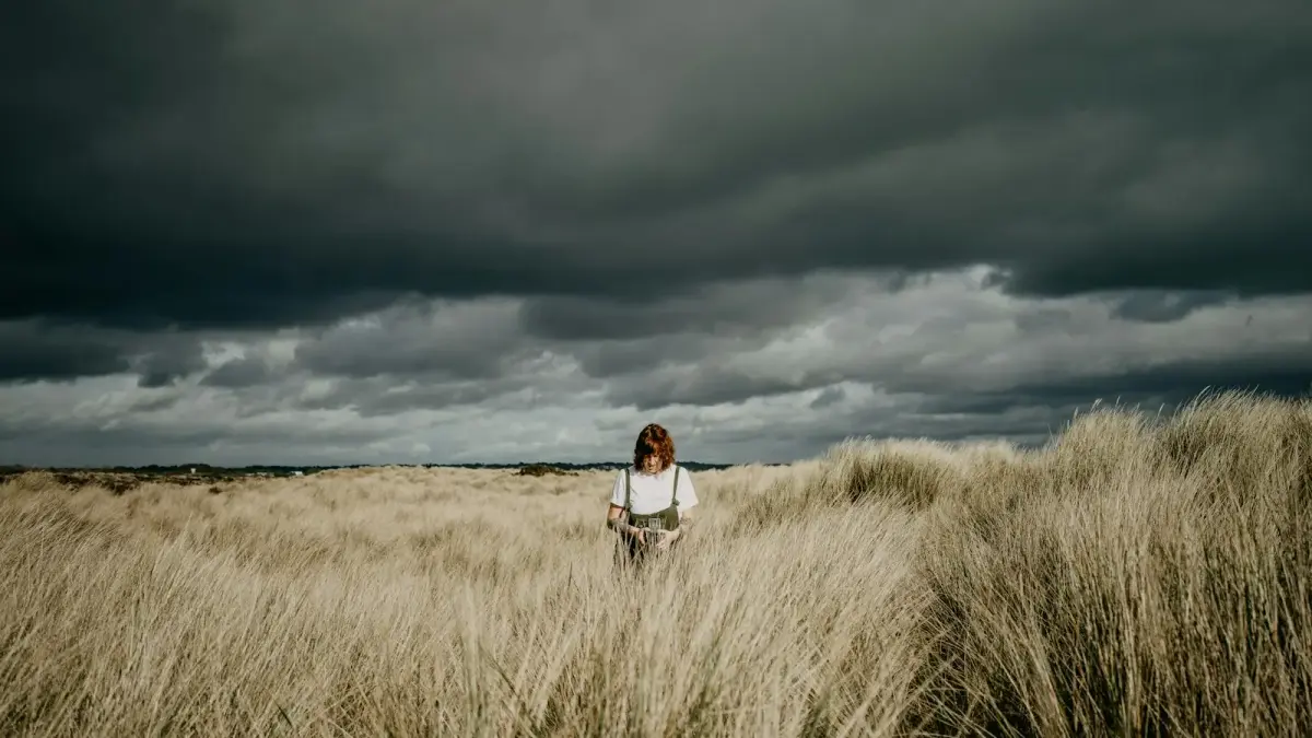a woman standing in a field of tall grass