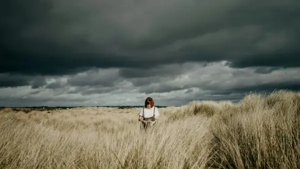 a woman standing in a field of tall grass