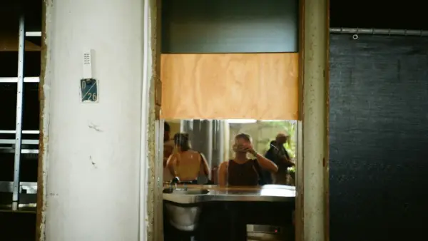 Three people seen through a doorway in a building.