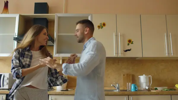 Couple dancing happily in a kitchen