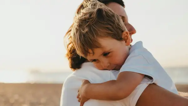 boy hugging woman during daytime