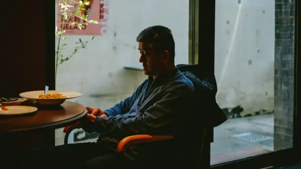 a man sitting at a table with a plate of food