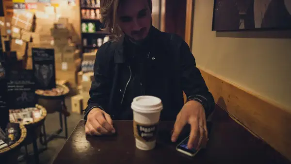 man sitting on chair holding phone
