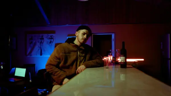 man in brown jacket sitting beside table
