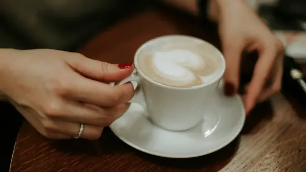 person holding white ceramic mug with coffee