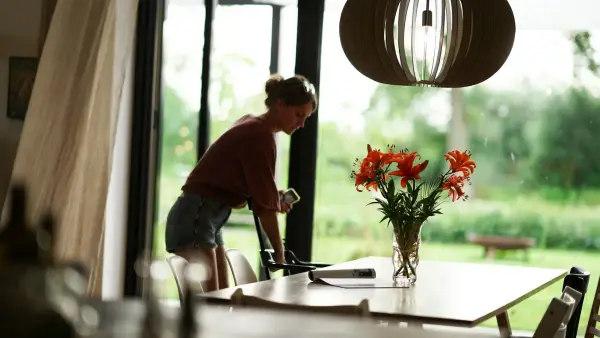 a woman sitting at a table with a vase of flowers