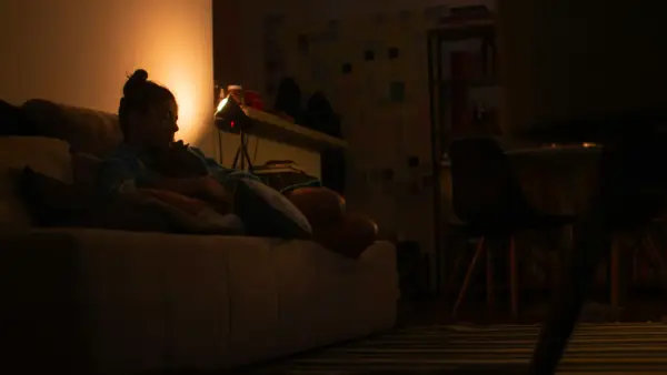 a person sitting on a couch in a dark room