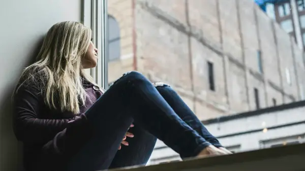 woman sitting on window watching sky