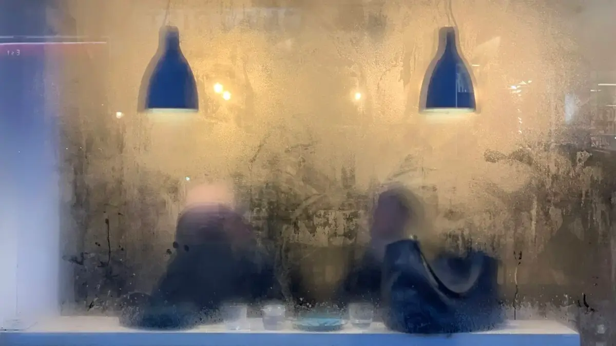 a couple of people sitting at a table with a light on top