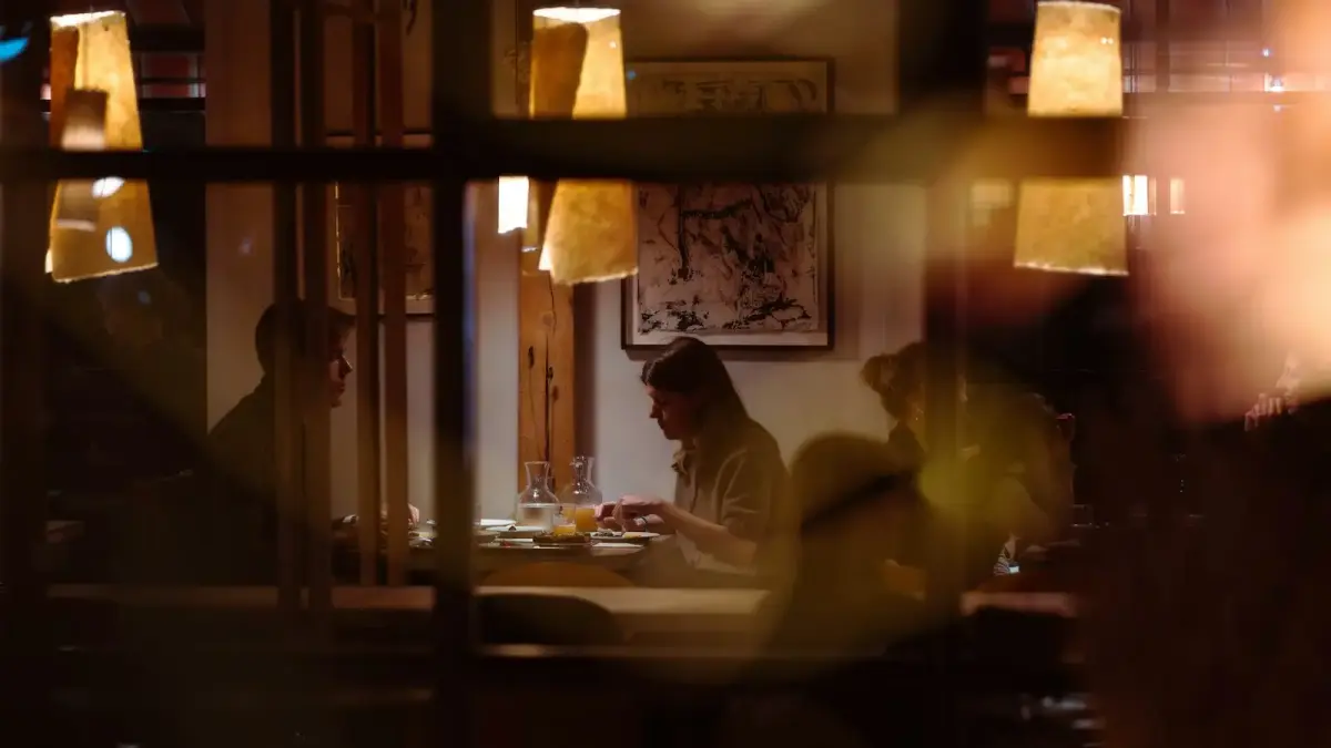 People dining at tables in a dimly lit restaurant.
