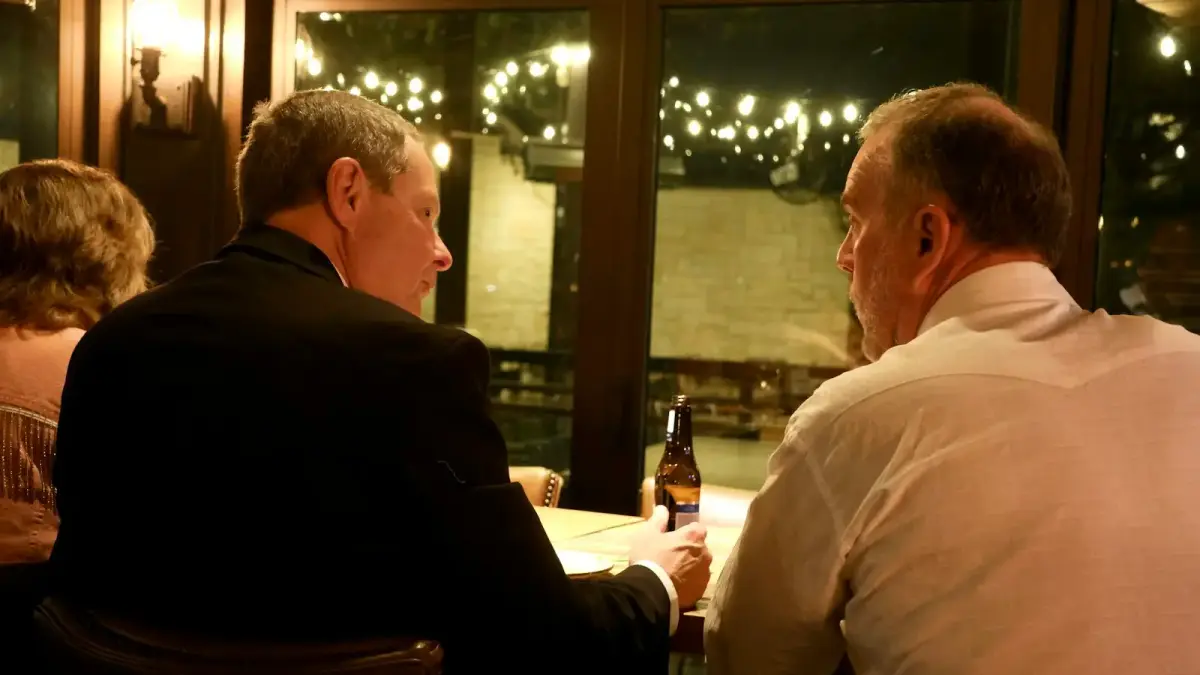 A couple of men sitting at a table next to each other