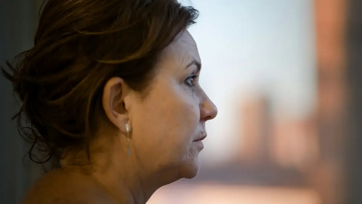 a close up of a person with a city in the background
