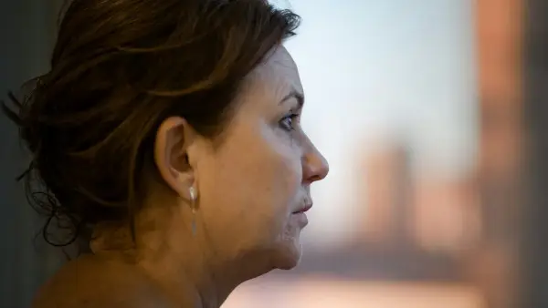 a close up of a person with a city in the background