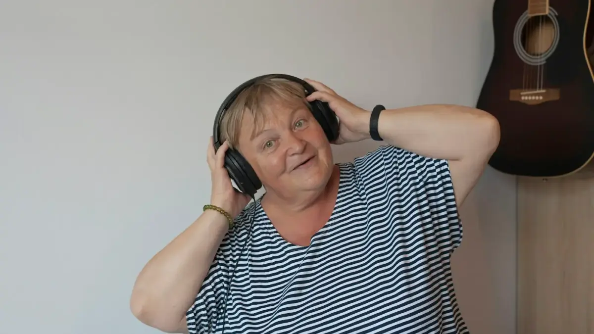 a woman with headphones and a guitar in the background