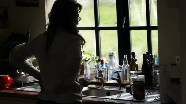 a woman standing in a kitchen next to a sink