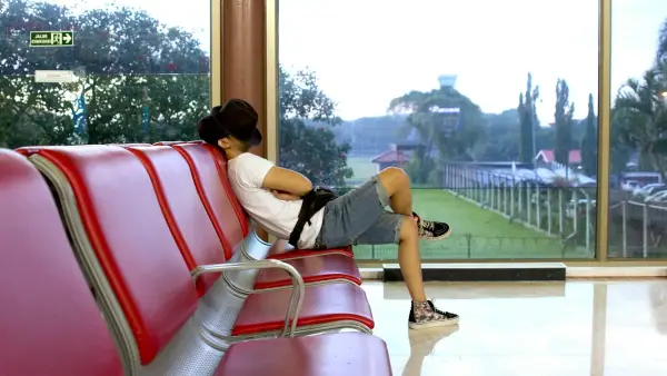 unknown person sitting on red gang chair indoors