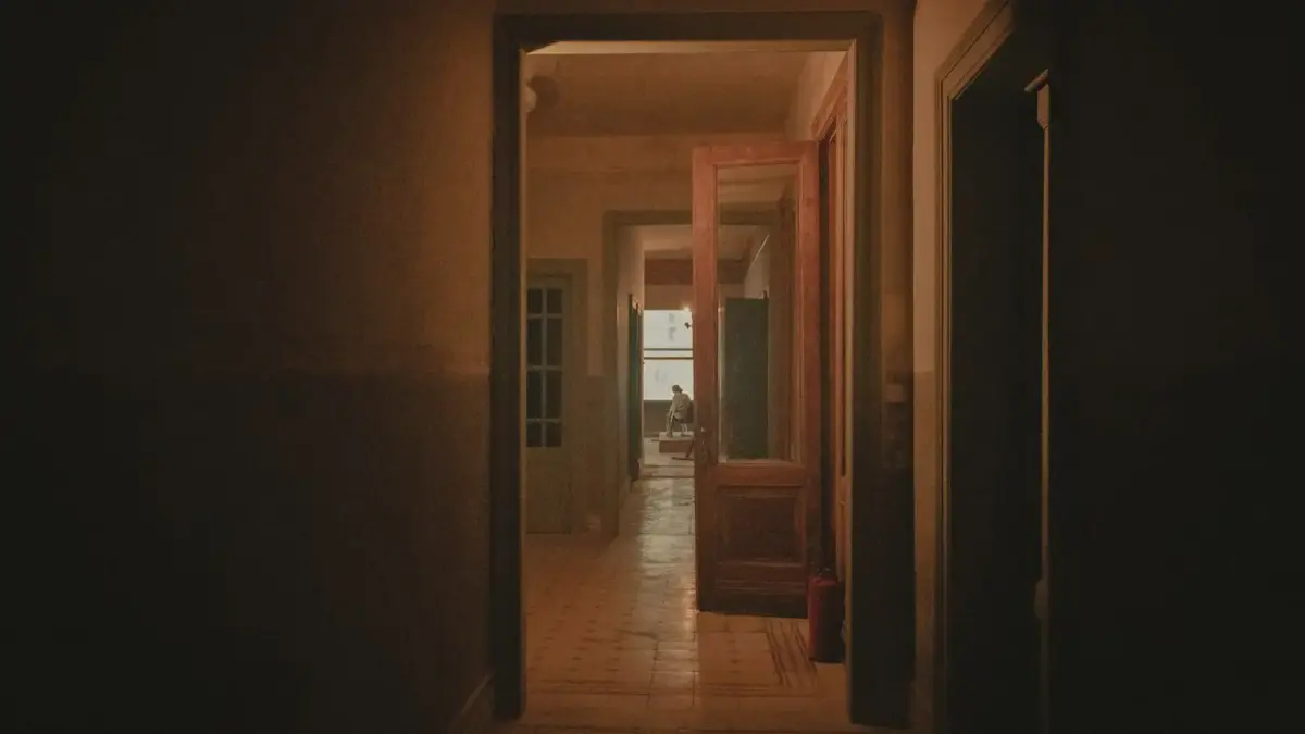 a hallway with a person sitting in the doorway