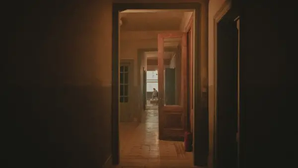 a hallway with a person sitting in the doorway