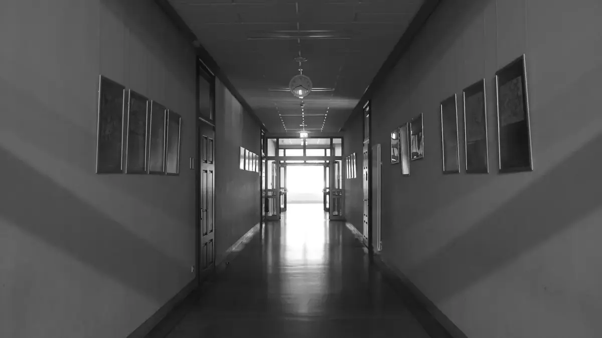A long, empty school hallway with doors and windows