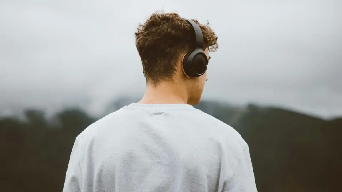 a man with headphones on looking at the mountains