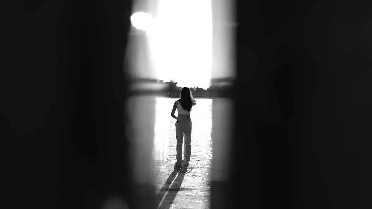 A person standing in a room with a light coming through the window