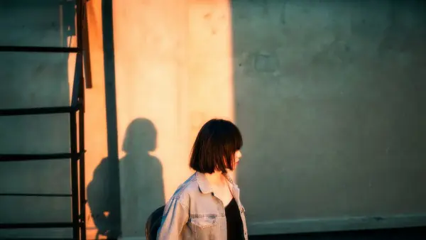 a woman walking down a street next to a building