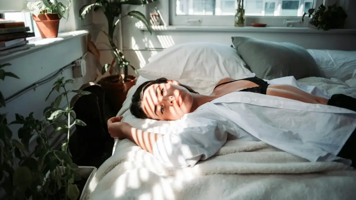 woman in white robe lying on bed