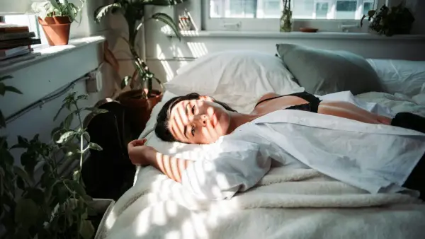 woman in white robe lying on bed