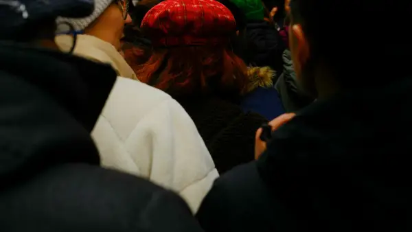 A woman in a red hat among a crowd