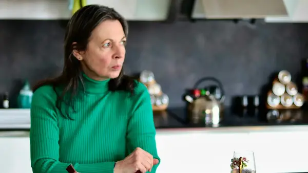 a woman sitting at a table in a kitchen