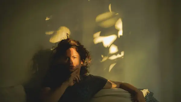 A man sitting on a couch in a dimly lit room