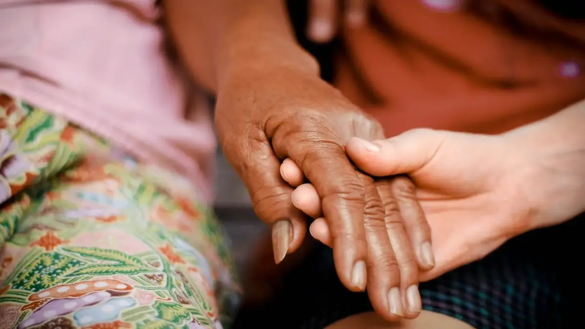 a close up of two people holding hands