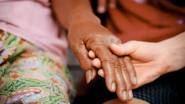 a close up of two people holding hands