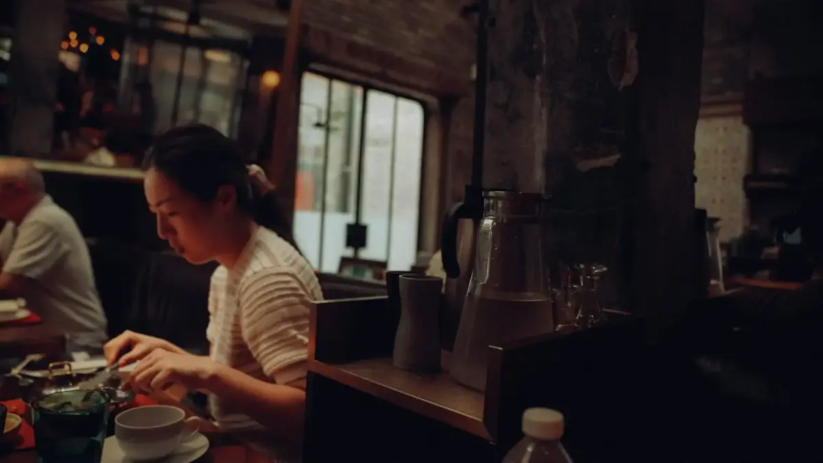A woman eating in a dimly lit, rustic restaurant.