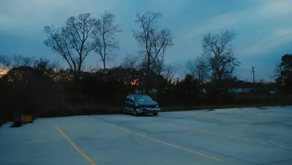 A car parked in an empty lot at dusk