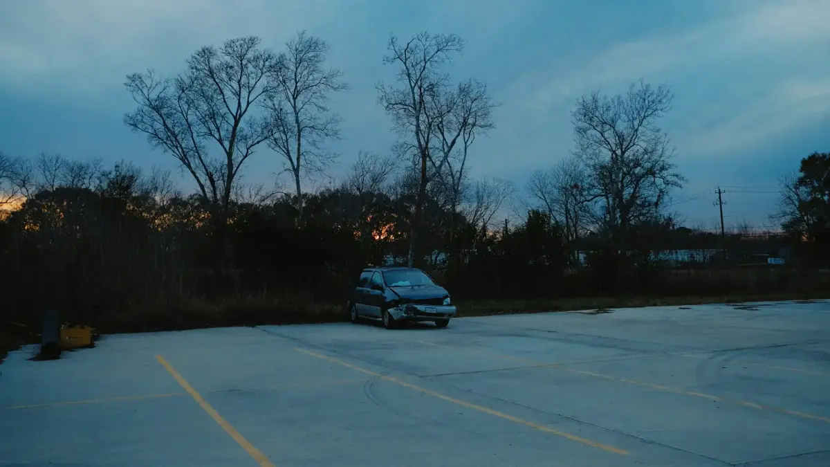 A car parked in an empty lot at dusk