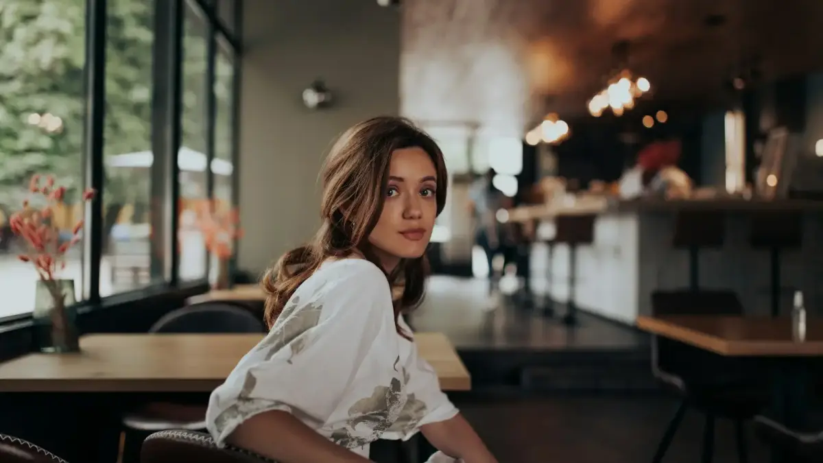 woman in white shirt sitting on brown leather chair