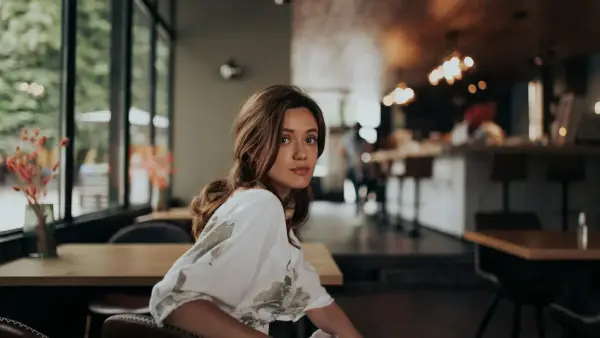woman in white shirt sitting on brown leather chair