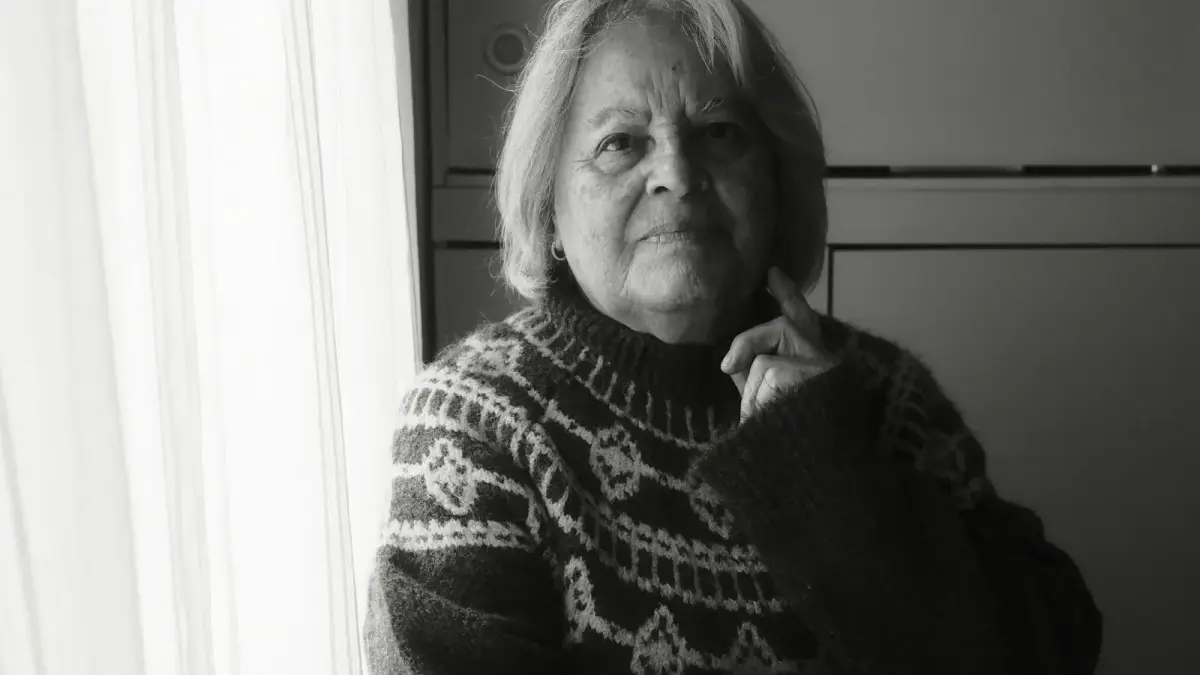 Elderly woman in patterned sweater near window