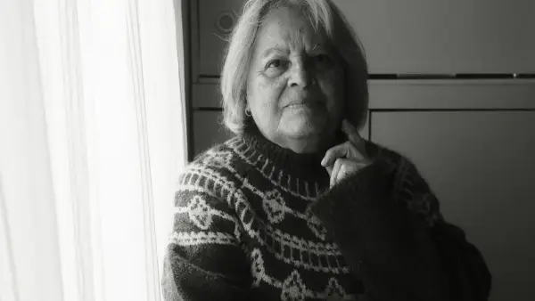 Elderly woman in patterned sweater near window