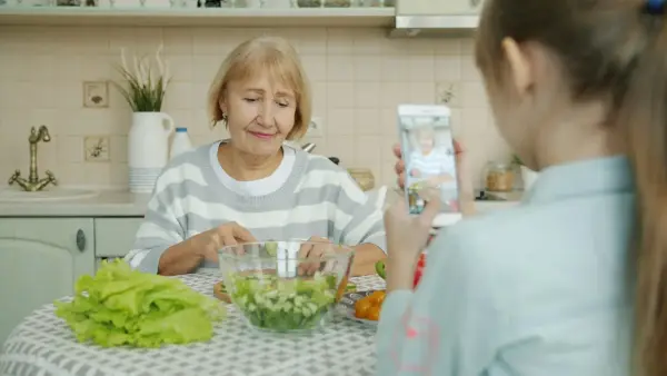 Grandmother and granddaughter making salad in kitchen
