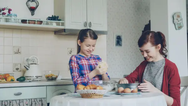 Mother and daughter bake together in the kitchen.