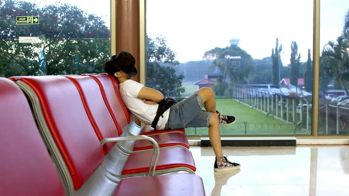 unknown person sitting on red gang chair indoors