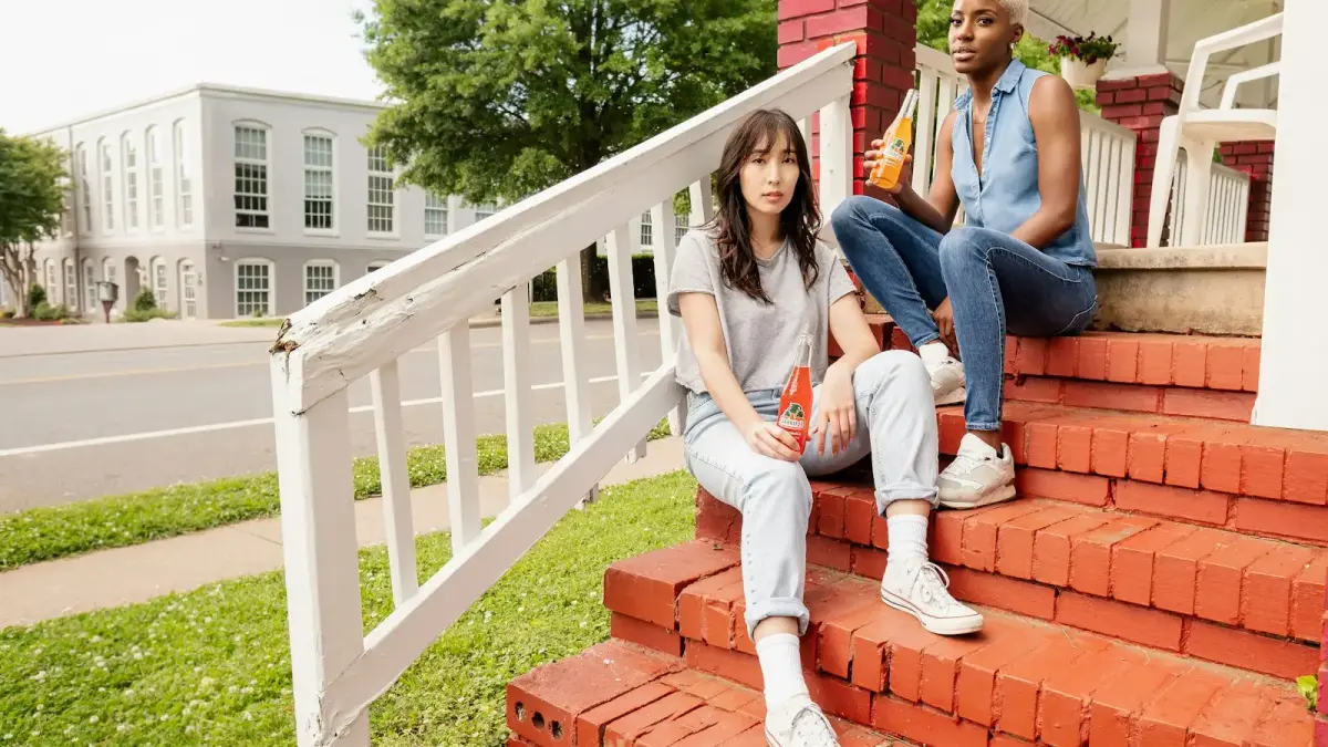3 women sitting on white wooden fence during daytime