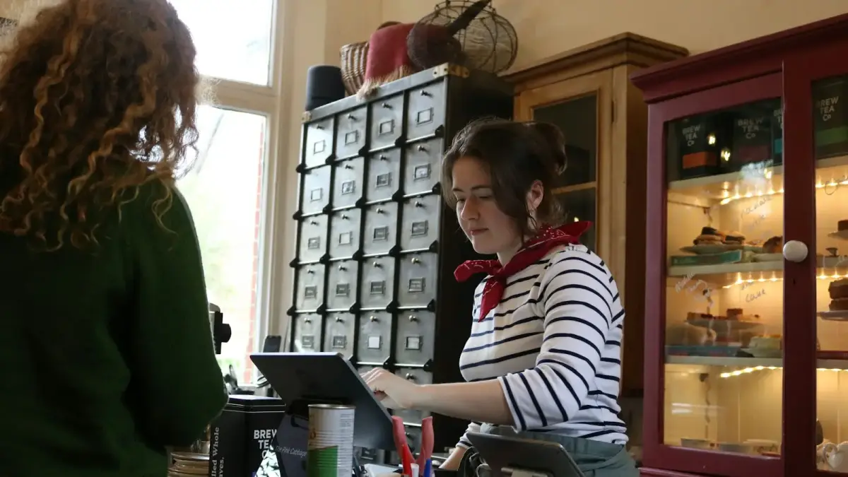 A cashier serves a customer at a shop counter