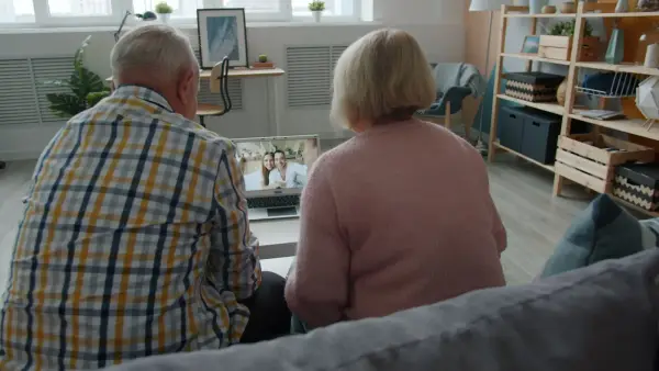 Elderly couple watching a video on laptop at laptop