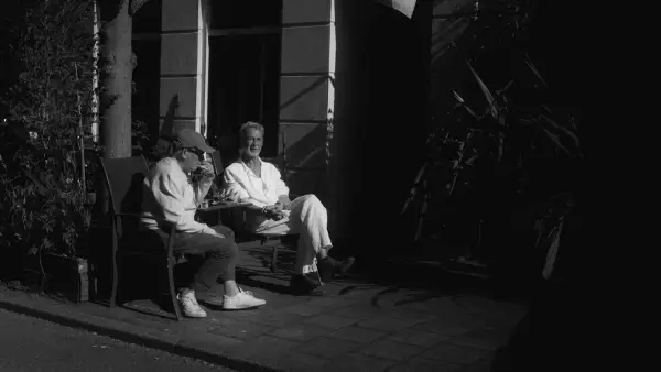Two people sitting on a bench outdoors at night.