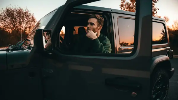 a man sitting in the passenger seat of a car