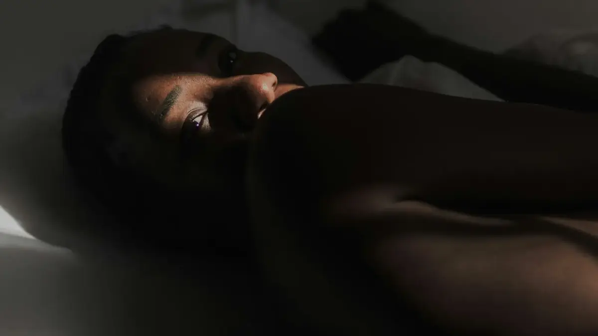 A woman laying on a bed with her eyes closed