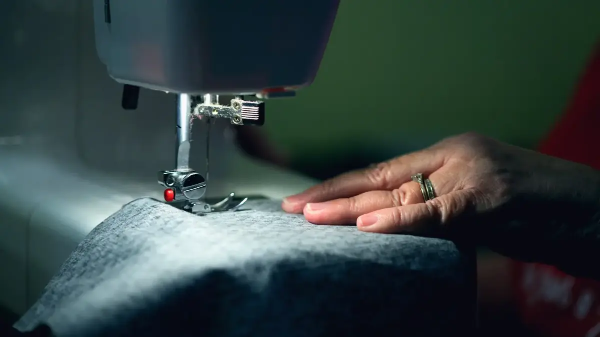 person in gray shirt sewing